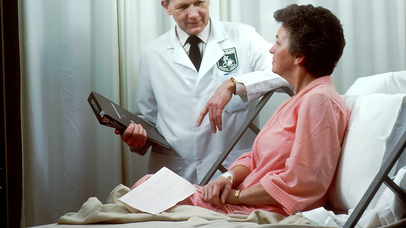 Doctor talking with an older patient in a hospital bed